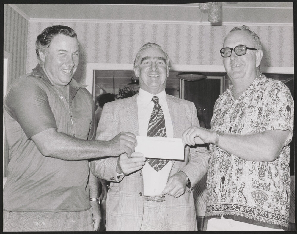 Three men holding a cheque